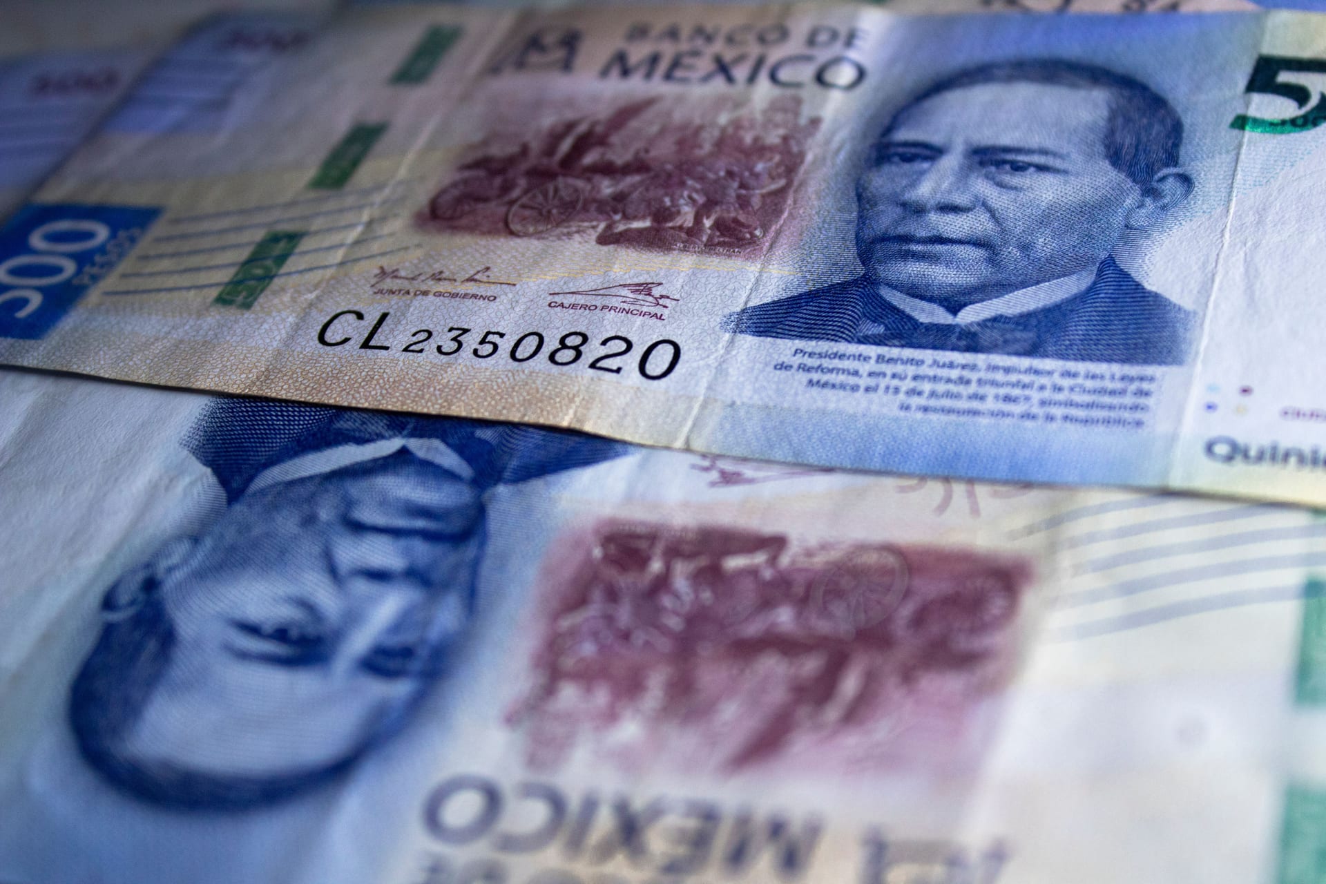 Varios billetes de 500 pesos mexicanos con el retrato de Benito Juárez, extendidos y superpuestos.