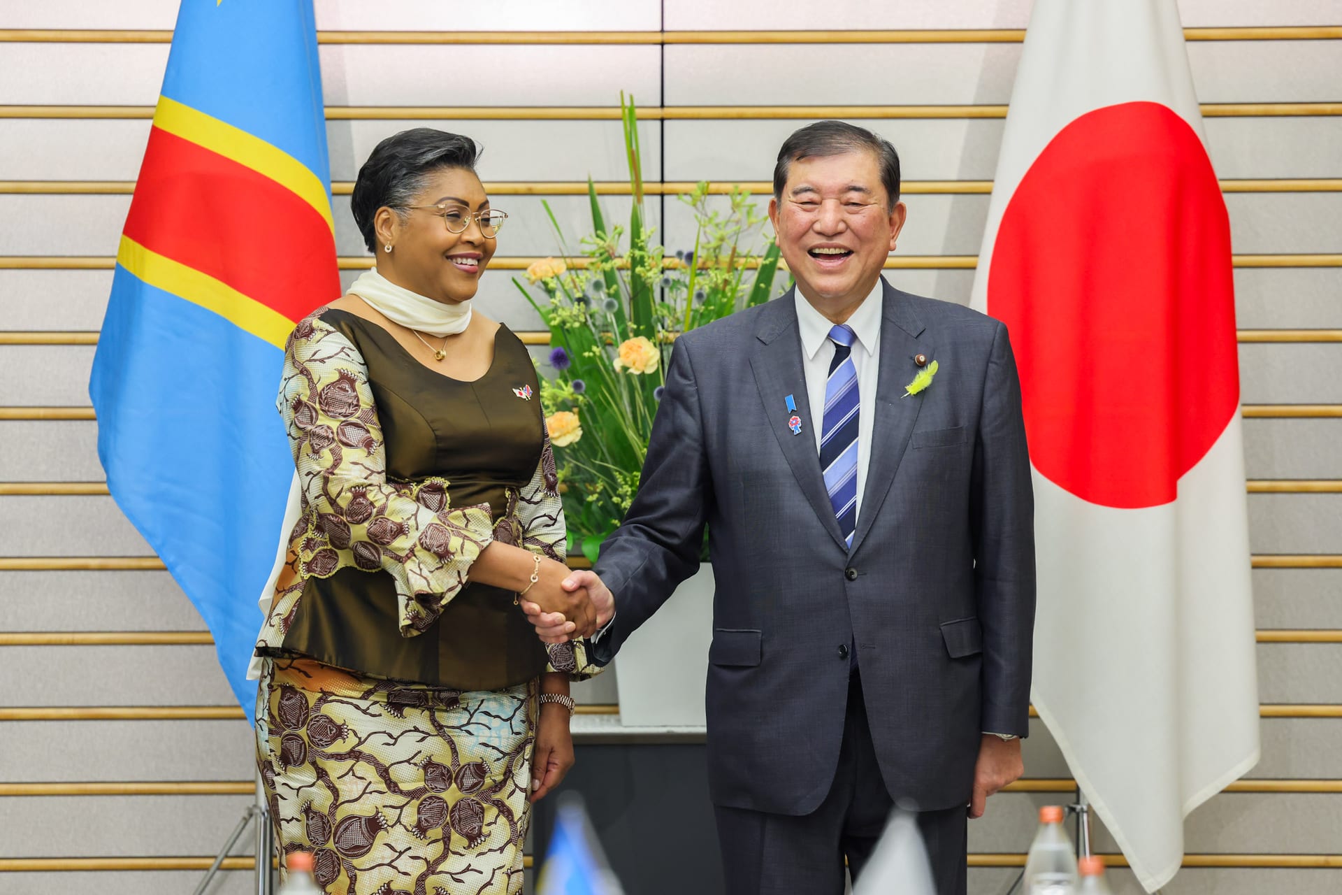 Judith Suminwa Tuluka estrecha la mano de un dignatario japonés durante un encuentro bilateral.