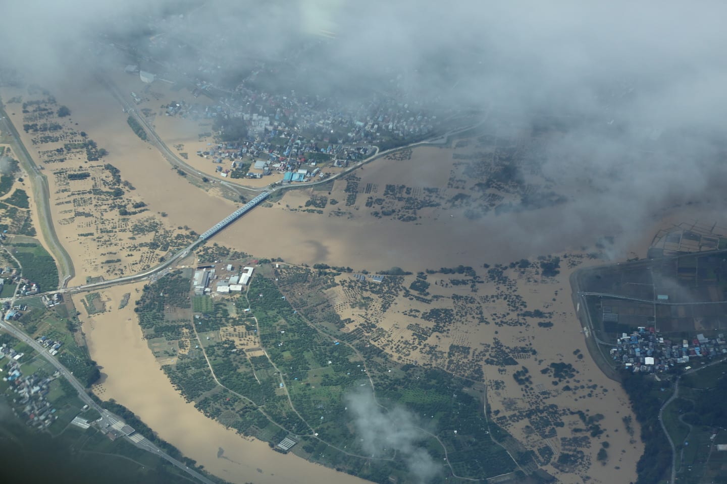 Vista aérea de un río desbordado que anega campos de cultivo y una zona poblada en una provincia japonesa tras un tifón.