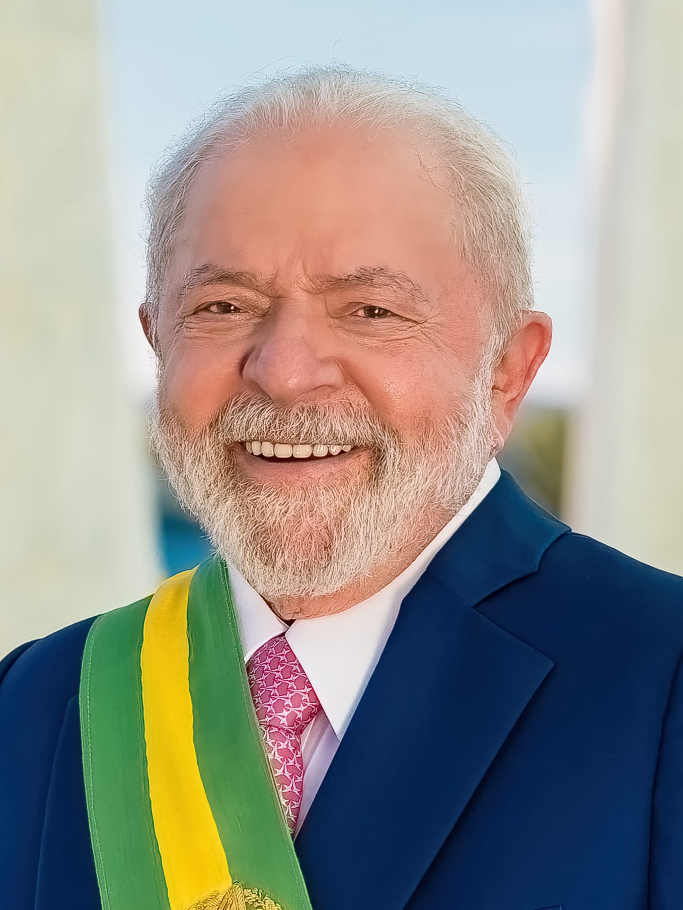 Retrato de un hombre mayor de cabello blanco y barba, con la banda presidencial verde y amarilla sobre un traje azul marino.