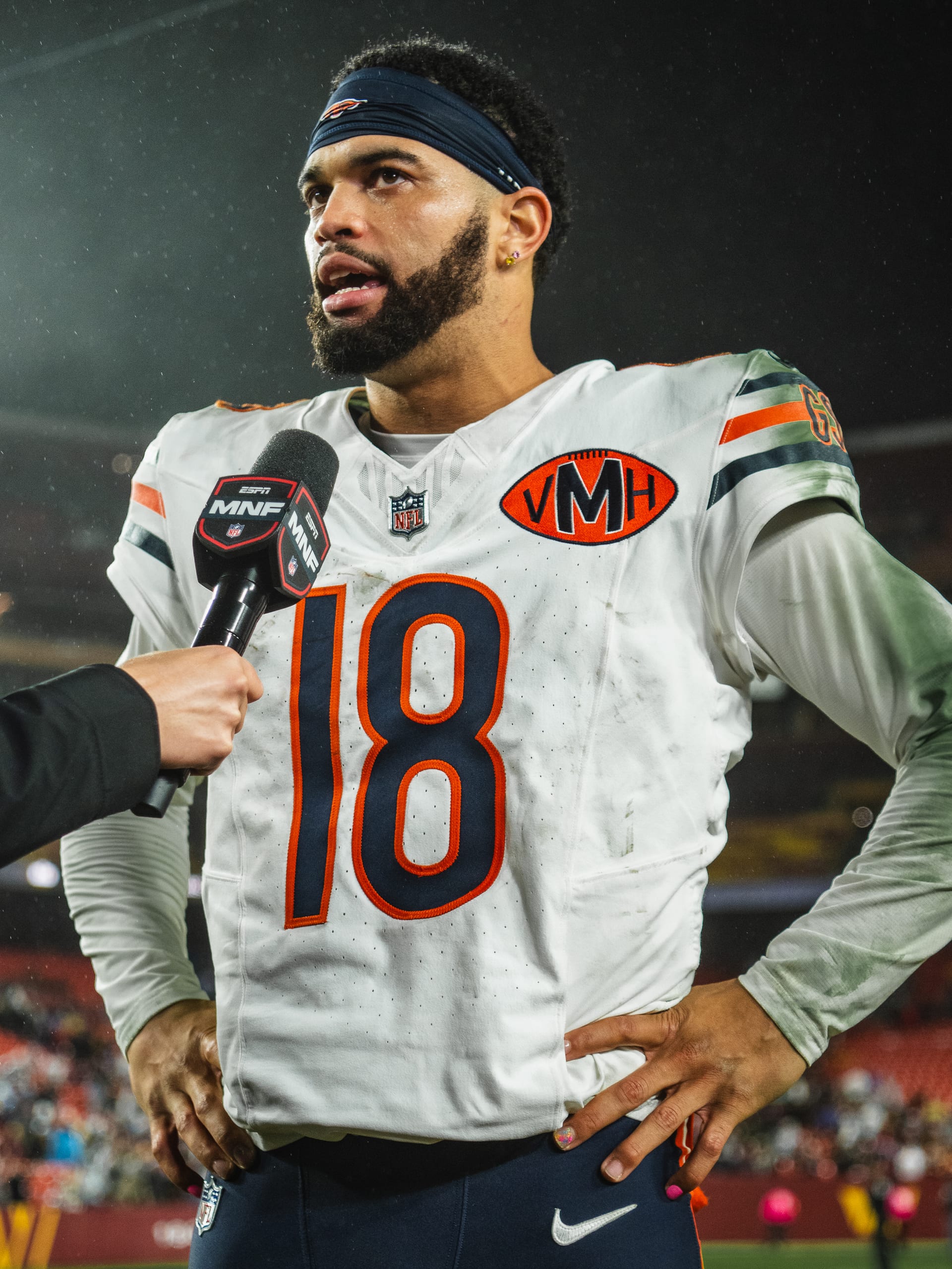 Caleb Williams, con la playera blanca de los Bears y el número 18, responde preguntas al término de un partido nocturno.