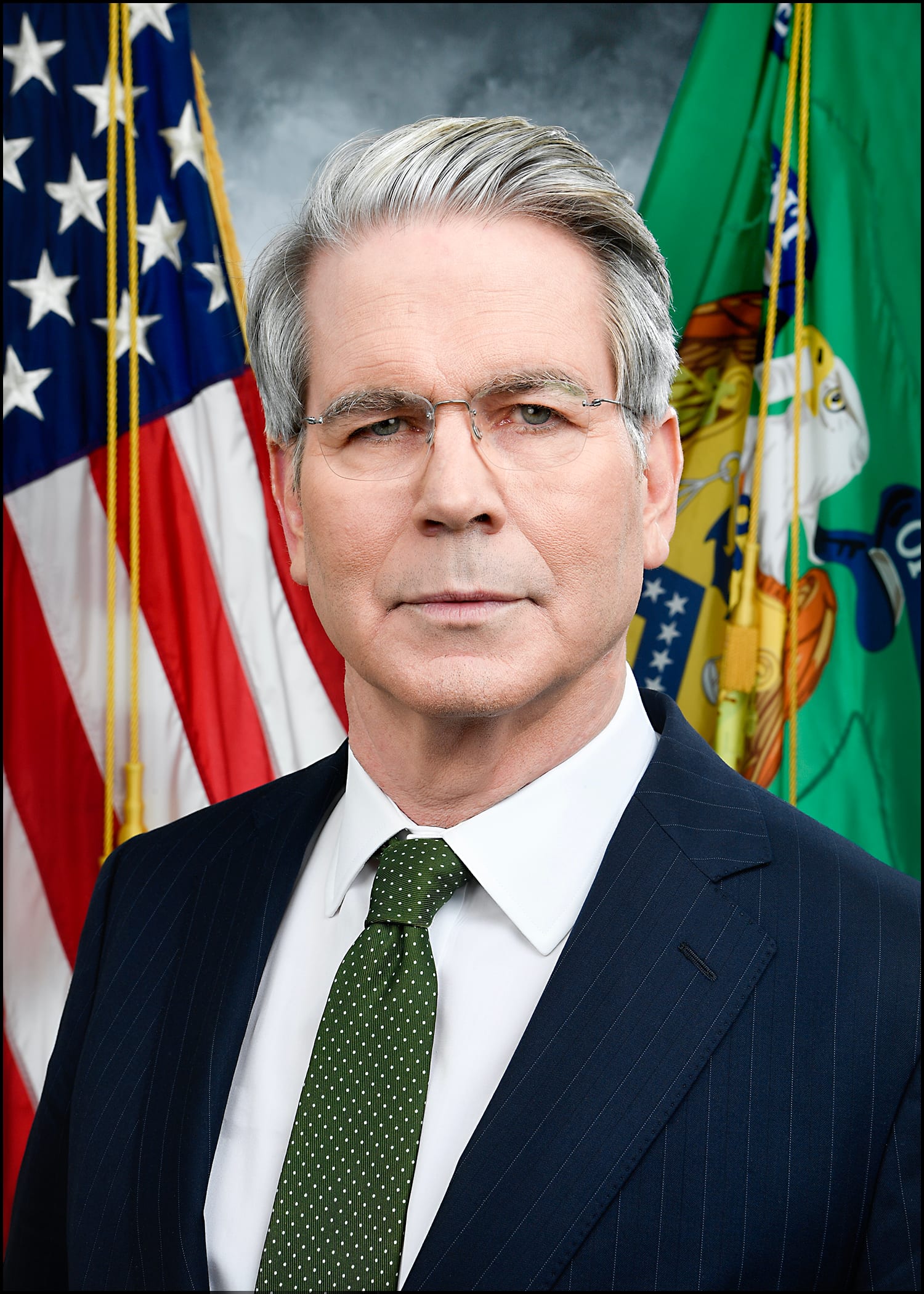 Retrato oficial de un hombre de cabello canoso, lentes sin marco y traje azul marino, frente a las banderas de Estados Unidos y del Tesoro.