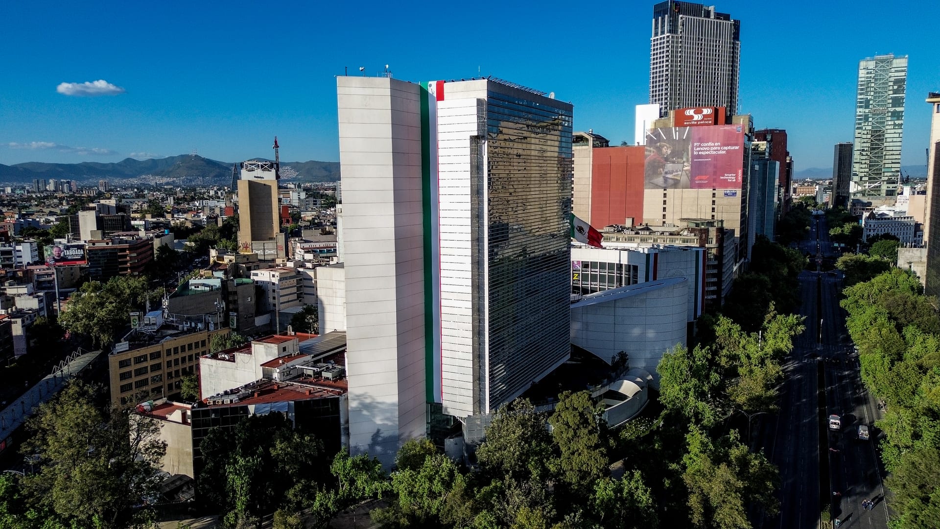 Vista aérea de la torre del Senado de la República, con una franja tricolor sobre la fachada, entre otros edificios de la Ciudad de México.