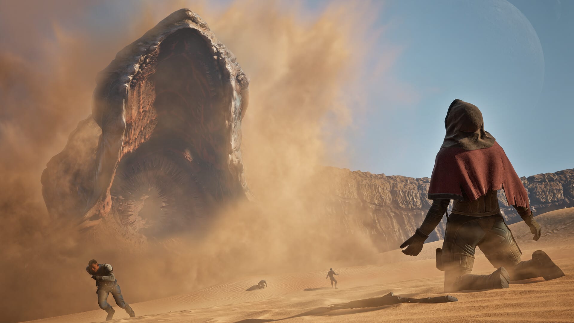 Un gigantesco gusano de arena emerge entre una nube de polvo frente a un personaje encapuchado en el desierto.