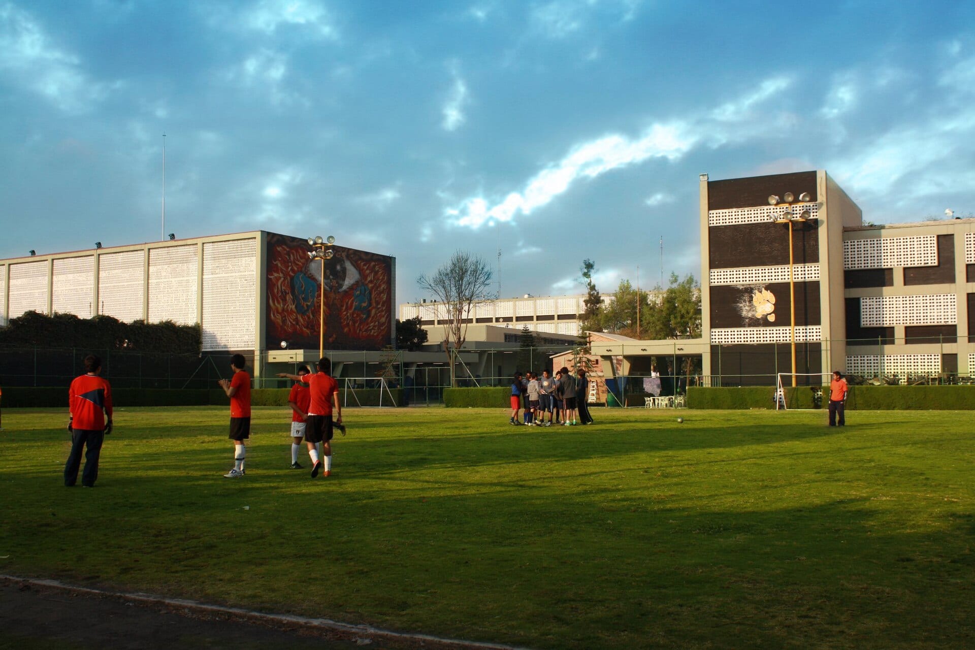 La cancha deportiva de la Escuela Nacional Preparatoria 8, con estudiantes practicando futbol frente a los edificios del plantel.