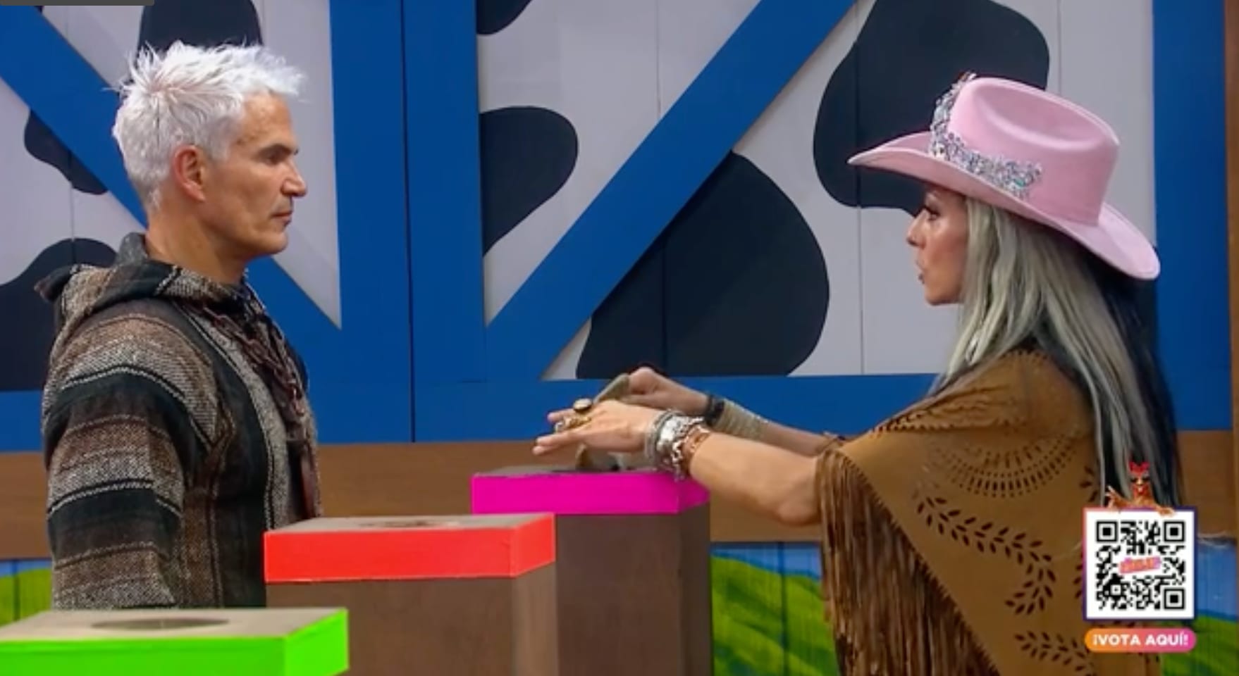 Julio Camejo e Ivonne Montero se encaran de frente sobre el foro de La Granja VIP, con cajas de colores entre ellos.