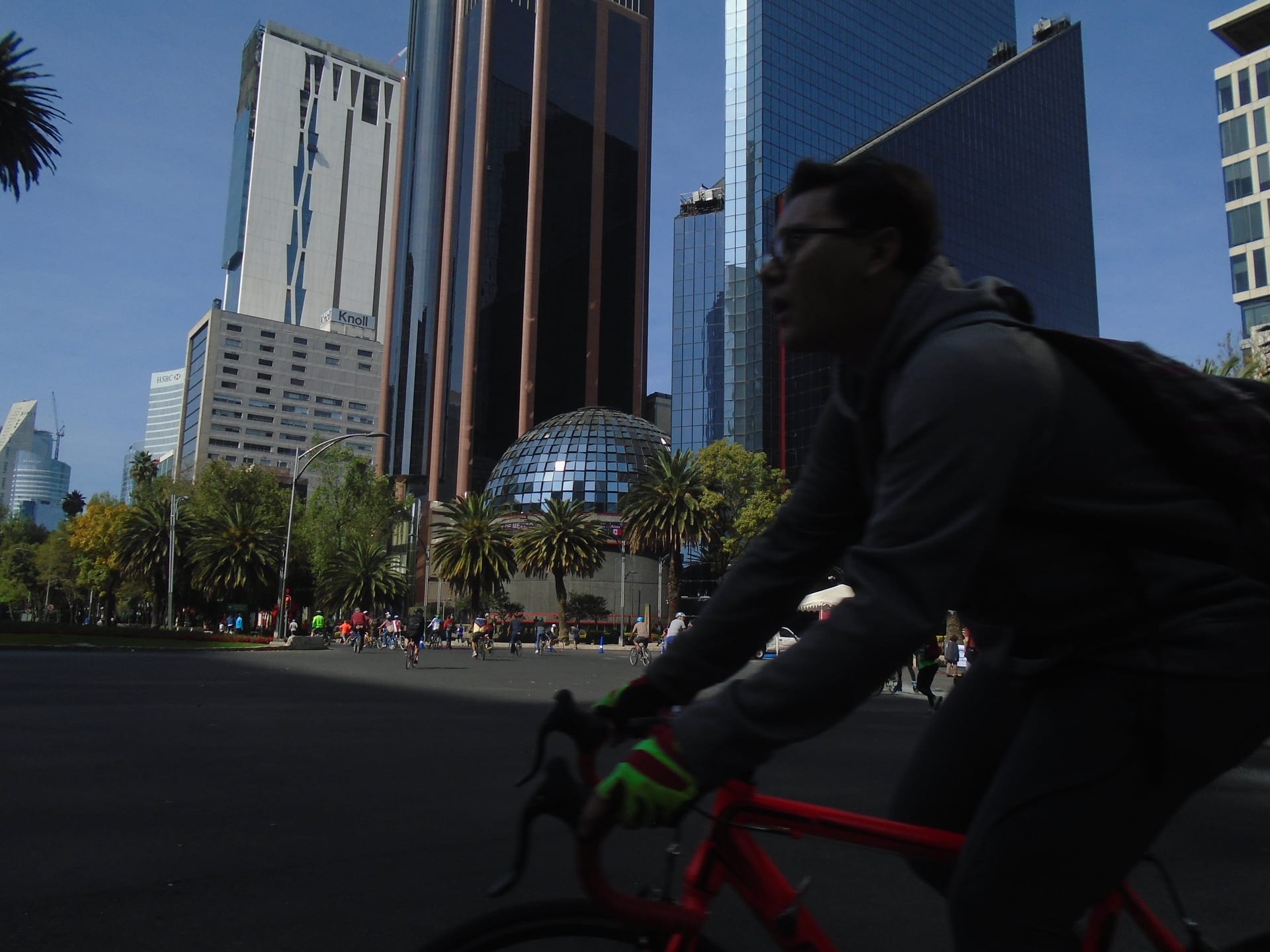 Un ciclista pasa por Paseo de la Reforma frente a la fachada esférica de cristal de la Bolsa Mexicana de Valores.