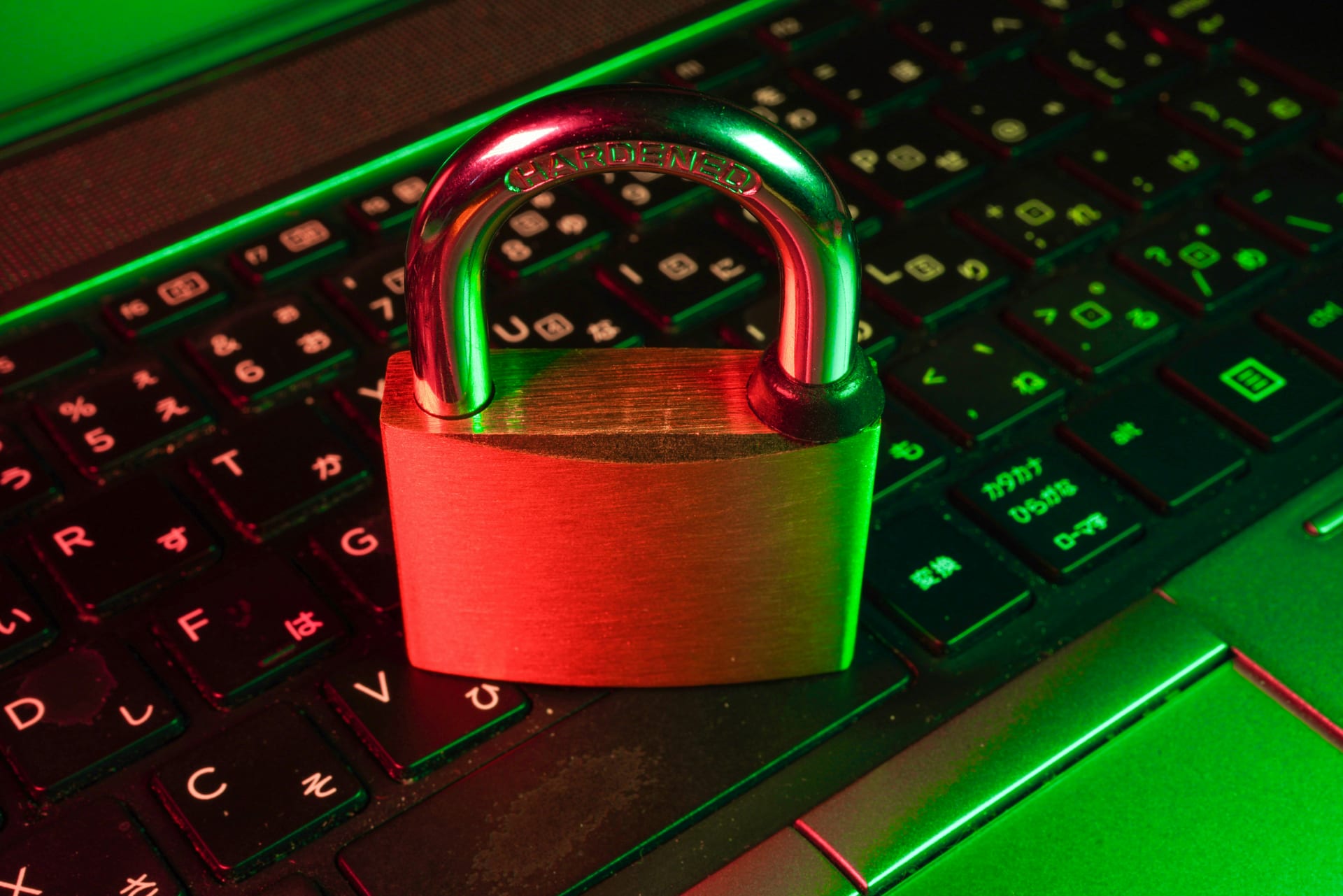 Un candado rojo apoyado sobre un teclado de computadora negro.