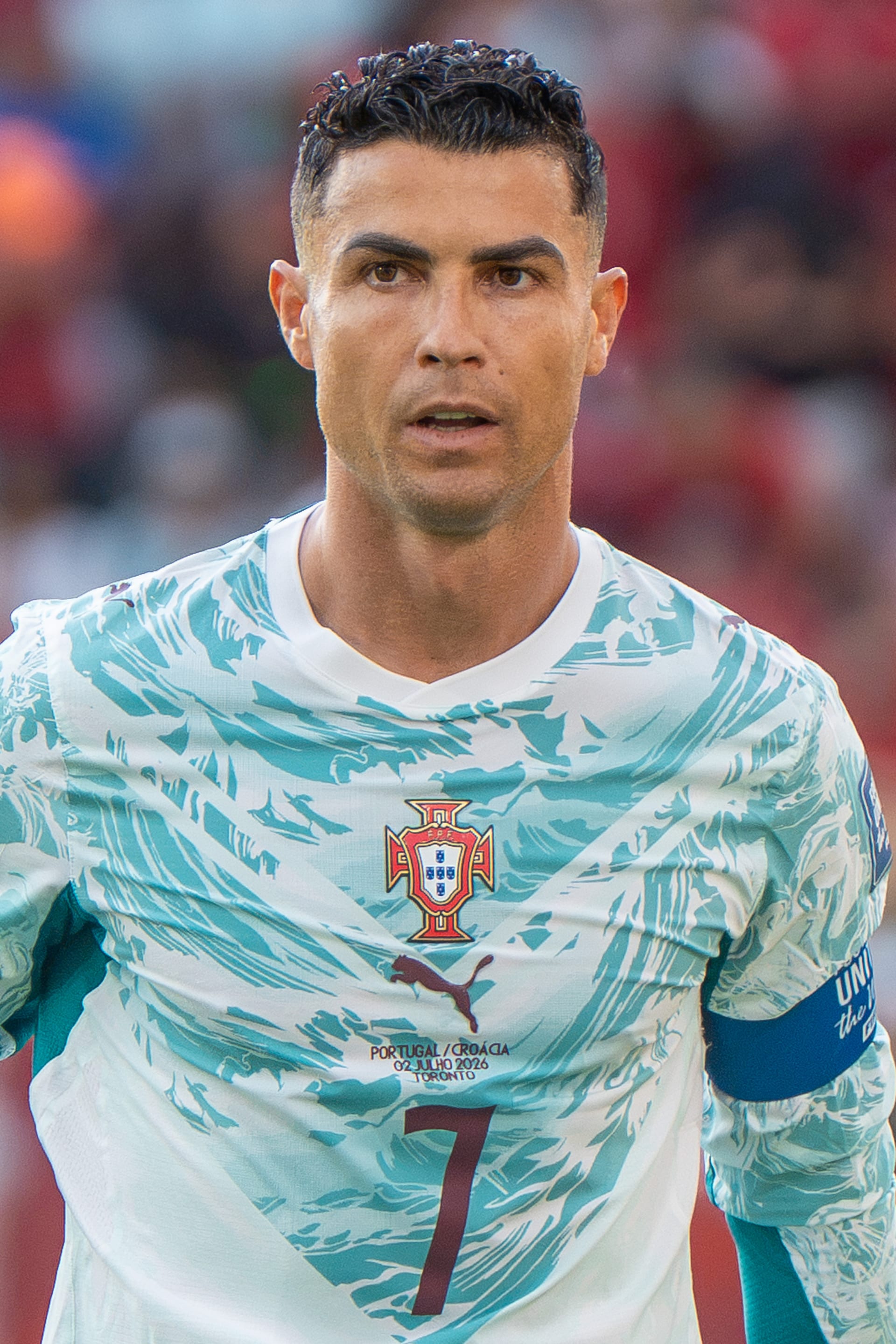 Cristiano Ronaldo, con el brazalete de capitán y el uniforme alterno de Portugal, mira hacia un costado con la boca entreabierta durante un partido.