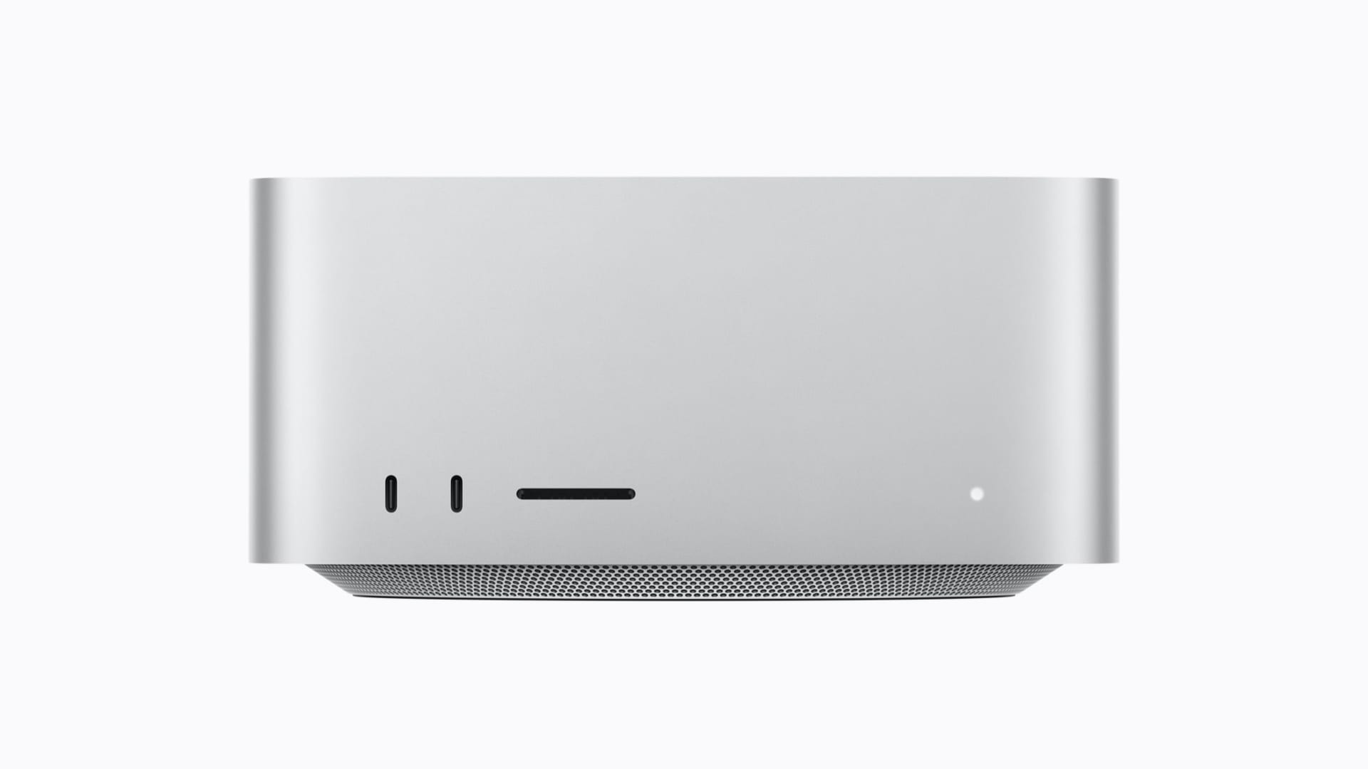 Vista frontal del Mac Studio, una computadora metálica compacta con un indicador luminoso y una rejilla de ventilación en la parte inferior.