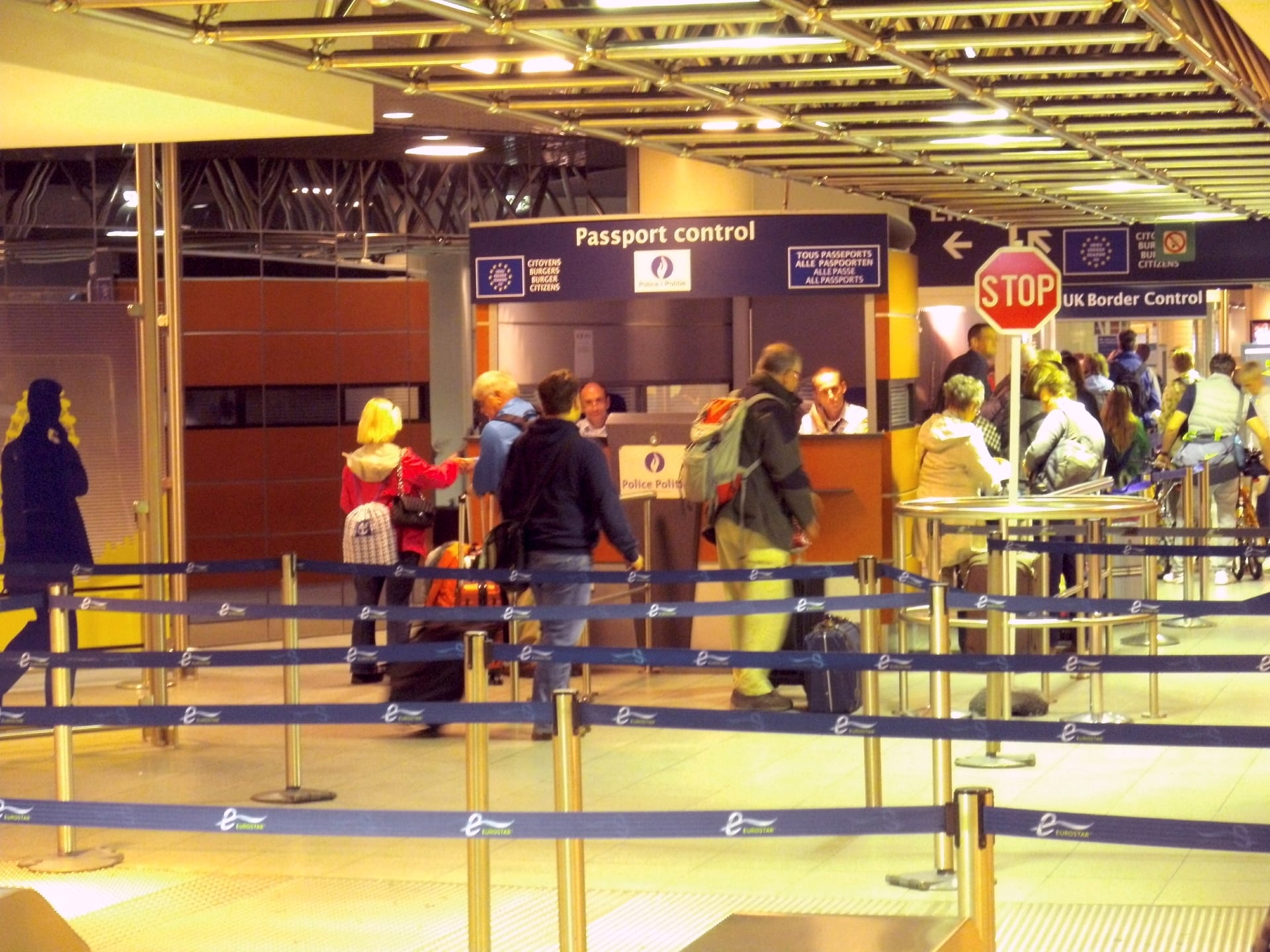 Un área de control de pasaportes con varias cabinas de vidrio en una estación de tren europea.