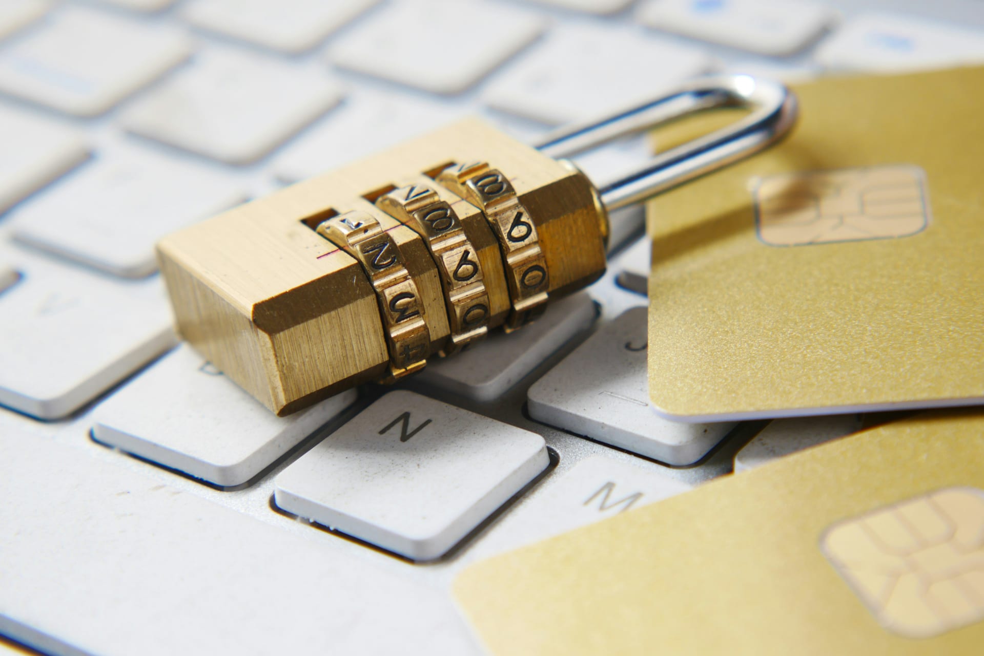 Un candado dorado colocado sobre un teclado de computadora.