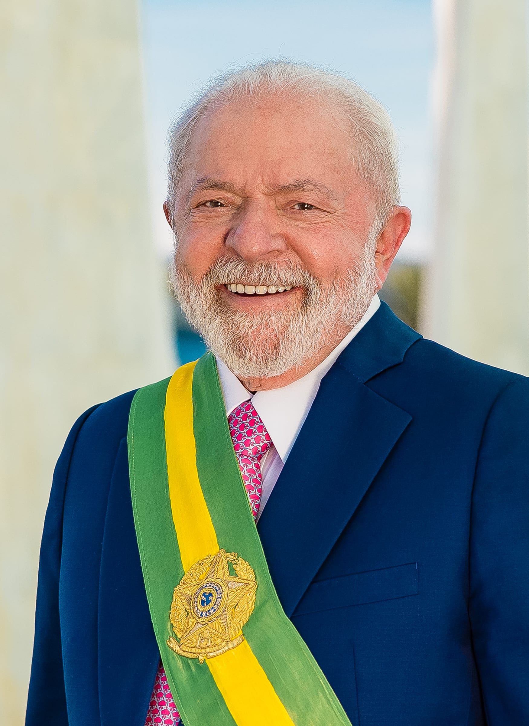 Lula da Silva sonríe con la banda presidencial verde y amarilla sobre un traje azul marino.