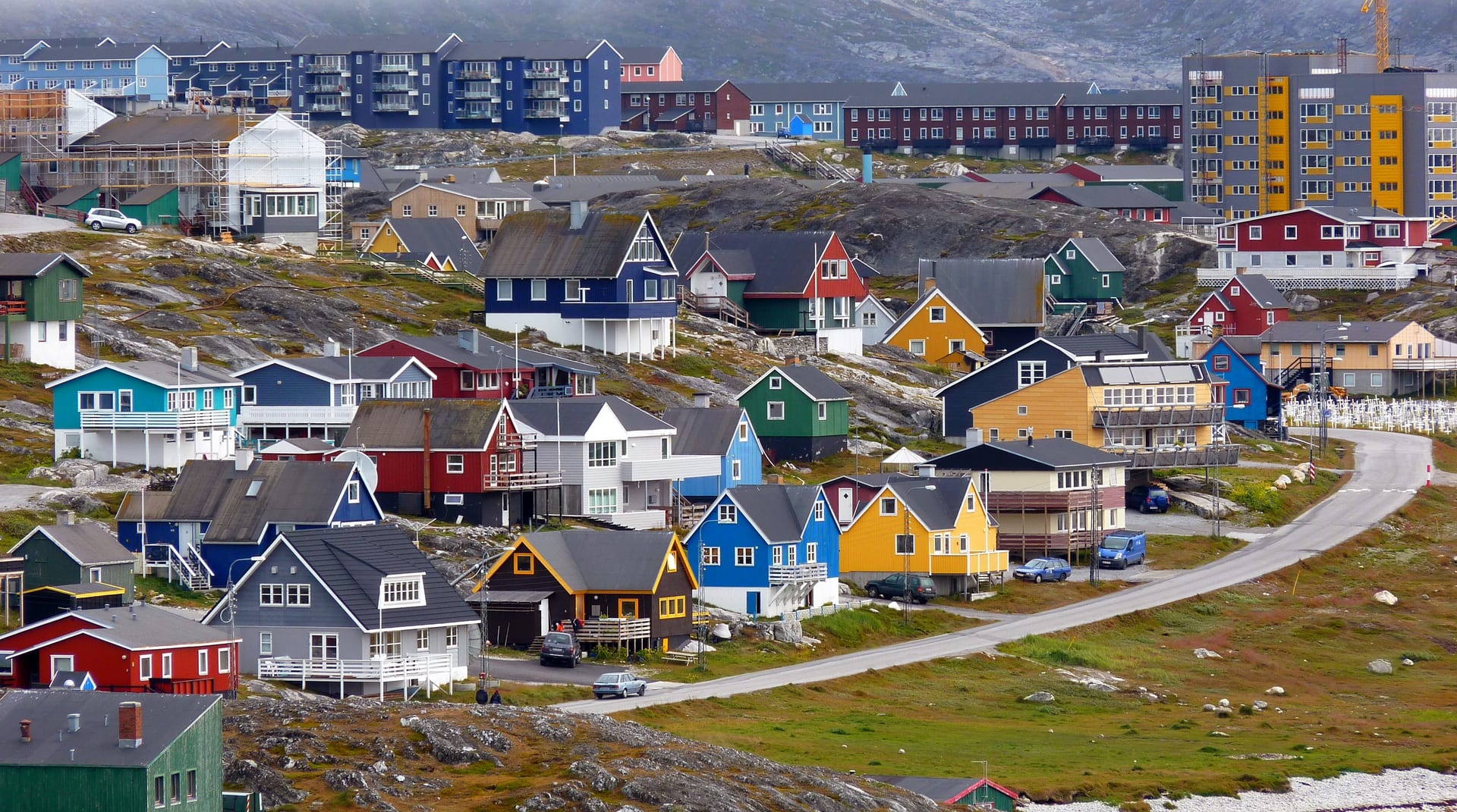 Barrio de Nuuk, la capital de Groenlandia, con casas de madera de colores sobre un terreno rocoso.