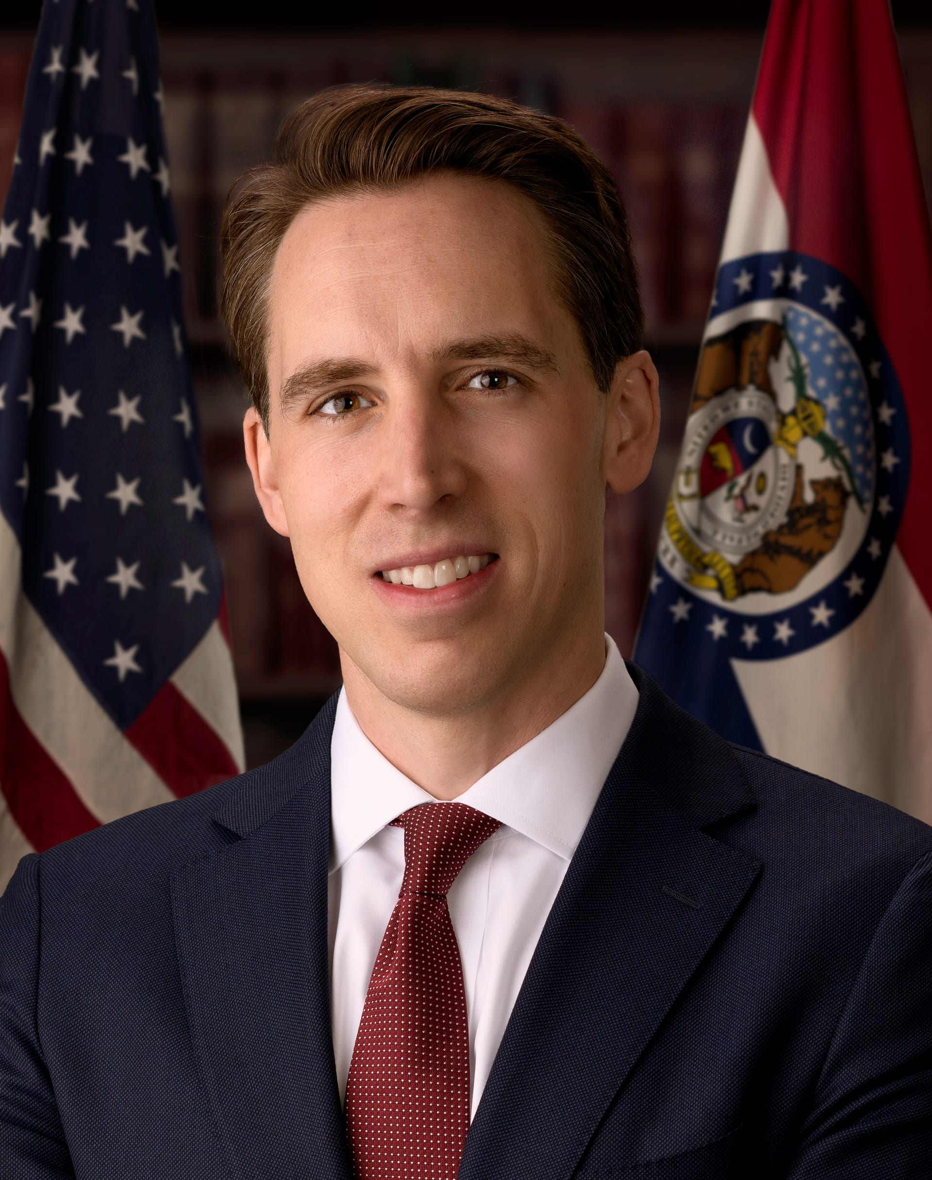 El senador Josh Hawley, quien preside el subcomité que convocó la audiencia, en un retrato oficial con la bandera de su estado detrás.