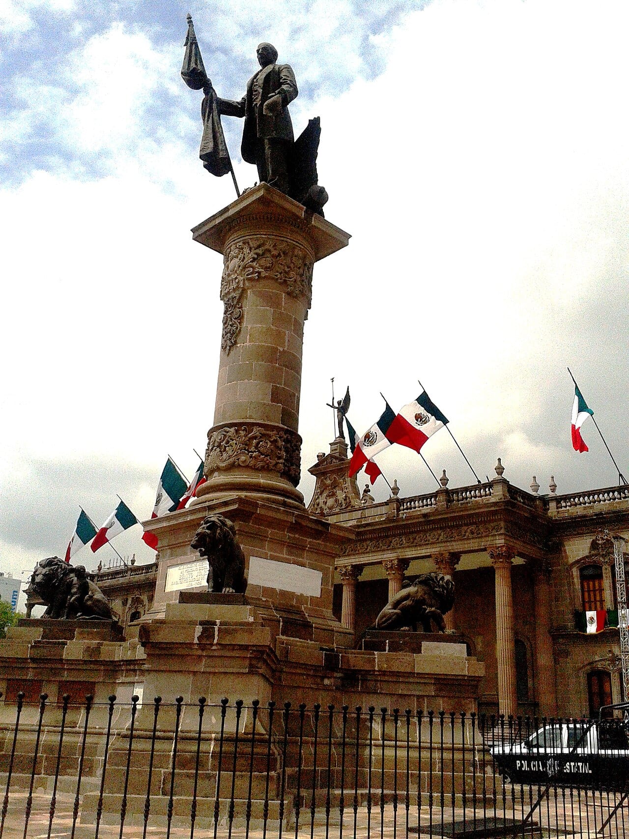 Columna con la estatua de Benito Juárez y leones de bronce, frente al Palacio de Gobierno de Nuevo León en Monterrey.