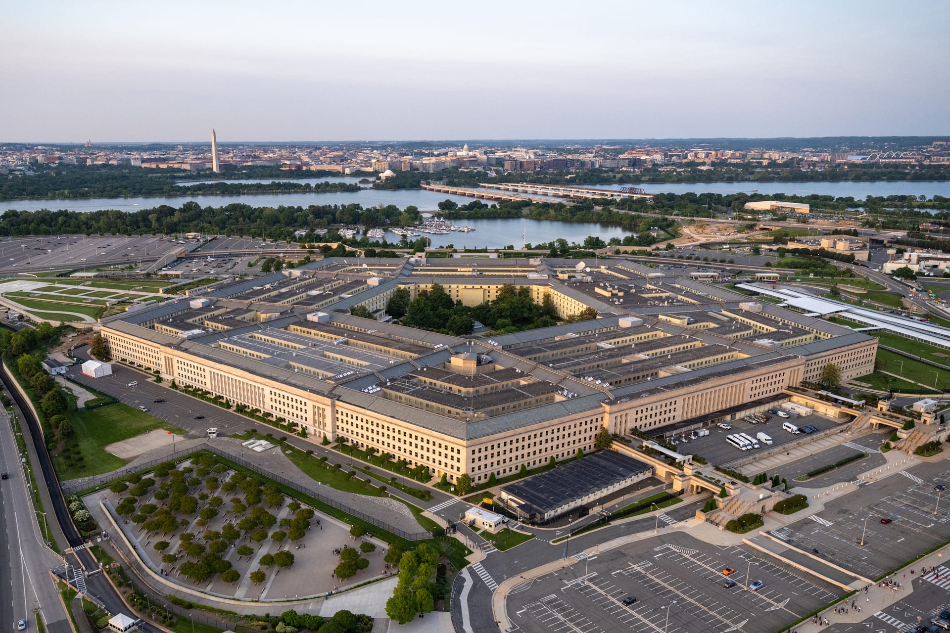 Vista aérea del edificio del Pentágono con su forma de cinco lados, estacionamientos alrededor y el Monumento a Washington al fondo.