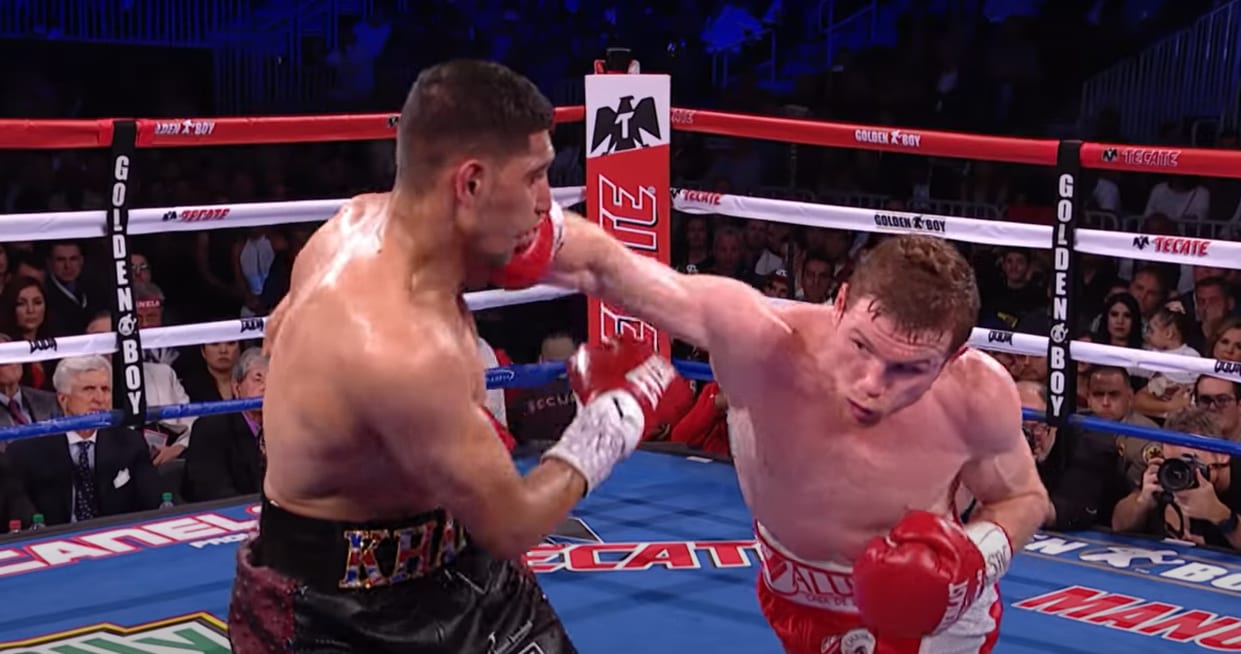 Canelo Álvarez conecta un golpe cruzado con el guante derecho durante una pelea sobre el cuadrilátero, con el público al fondo.