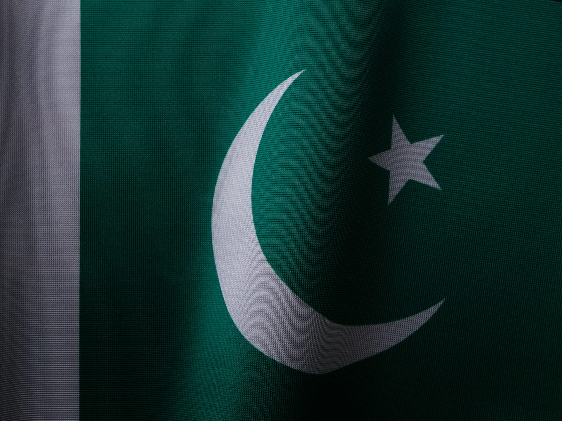 Bandera de Pakistán, verde con la media luna y la estrella blancas, ondea al viento.
