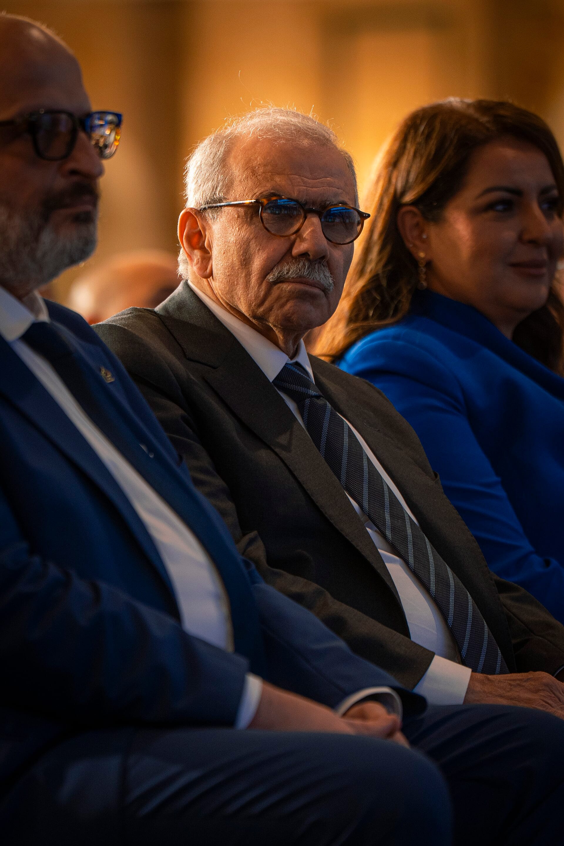 El primer ministro libanés Nawaf Salam, con lentes y bigote canoso, sentado entre otros asistentes a un evento.